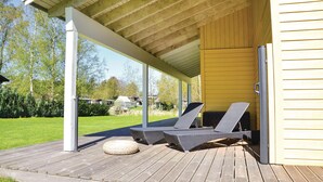 A covered outdoor seating area with two lounge chairs and a woven ottoman. - Cozy home in Jægerspris with WiFi (Jægerspris)