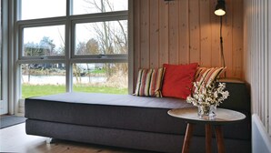A cozy seating area with a bench, a small table with a vase, and a lamp. - Cozy home in Jægerspris with WiFi (Jægerspris)