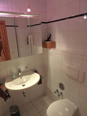 Een haardroger, handdoeken, zeep, toiletpapier