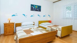 Ein Schlafzimmer mit zwei Betten, einem Nachttisch aus Holz und einem Bild an der Wand.
