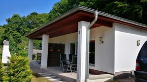 Un petit bâtiment d’un seul étage, doté d’un porche abrité, avec le numéro « 2 » bien visible et une voiture garée à proximité.
