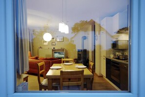 Una cocina moderna con comedor, televisor y refrigerador.