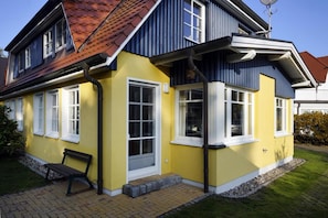 A two-story house with a yellow facade, a red-tiled roof, and a satellite dish. - Hagens Hus - Hagens Hus (Prerow)