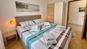 Ein Schlafzimmer mit Bett, Nachttischlampen, einem Nachttisch und einem Bild an der Wand.