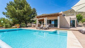 A swimming pool with lounge chairs, a covered patio, and a stone building with a view of the surrounding landscape. - Awesome home in Puerto de Alcudia (Puerto de Alcudia)