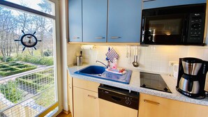 A kitchen with a dishwasher, microwave, and coffee maker. - Residence Bleichröder, App. 27 - Residence Bleichröder Villa Rosengarten (Heringsdorf)