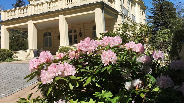 A large, classical building with a symmetrical facade, prominent columns, and a balcony. - Residence Bleichröder, App. 27 - Residence Bleichröder Villa Rosengarten (Heringsdorf)