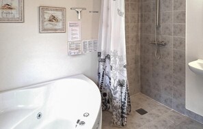 A bathroom with a bathtub, shower, and toilet.