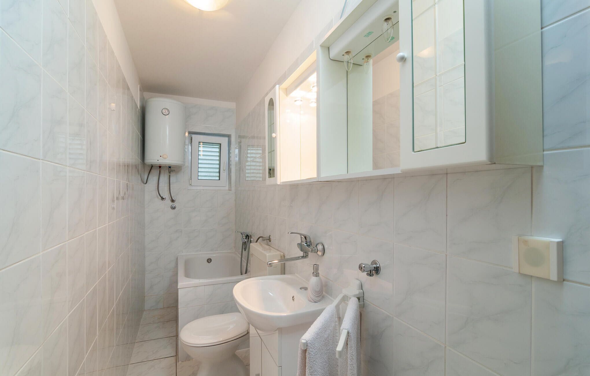 Une salle de bain avec des toilettes, un lavabo et une douche.