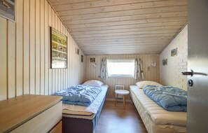 A small, cozy room with two single beds, a wooden ceiling, and a window with curtains. - Lovely home in Rømø with sauna (Rømø)