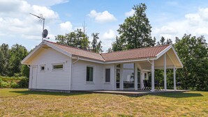 A single-story white house with a red-tiled roof and a covered porch. - Stunning home in Bolmsö with sauna (Bolmsö)
