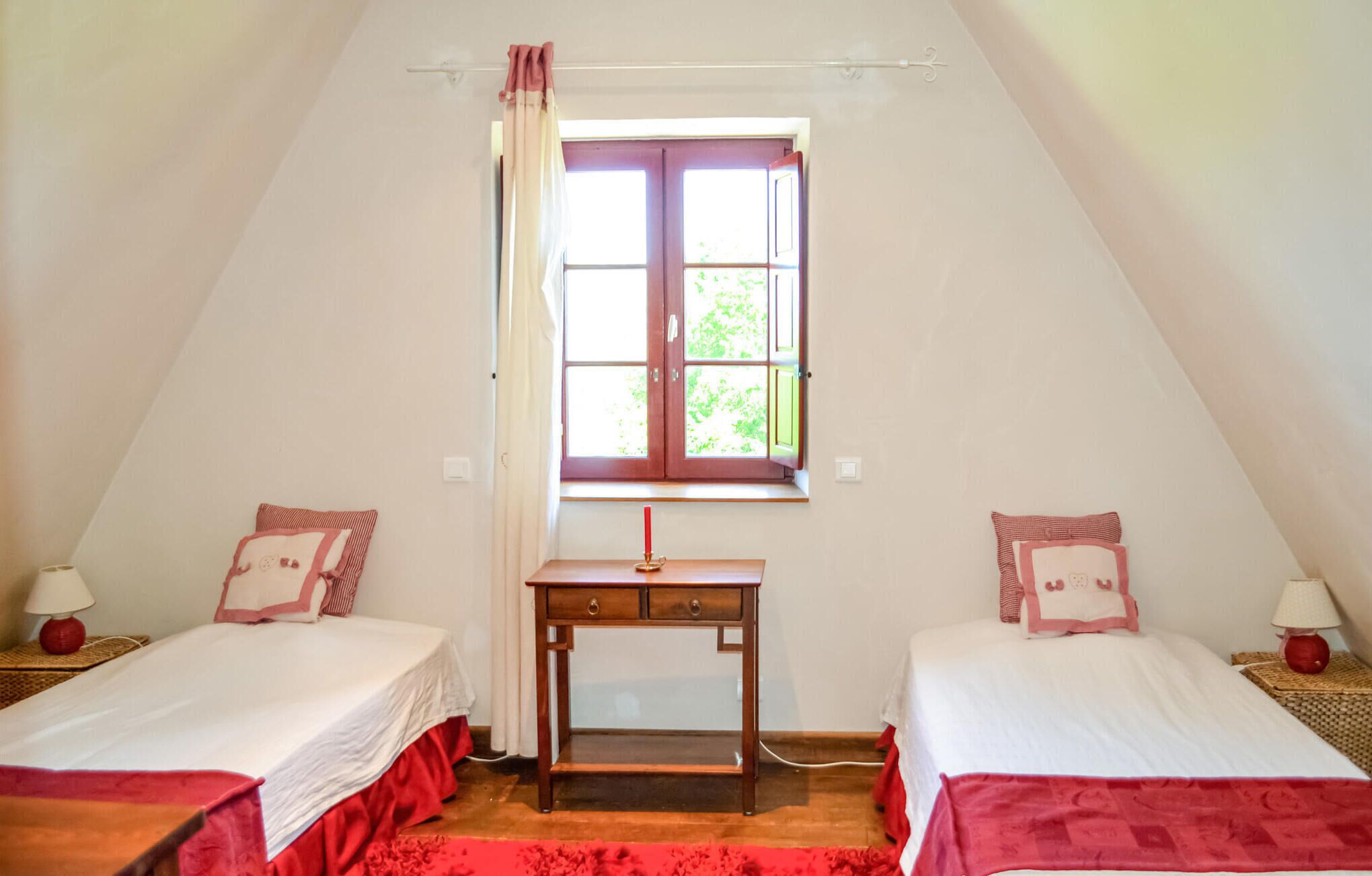 Un dormitorio con dos camas, un escritorio y una ventana con cortinas.