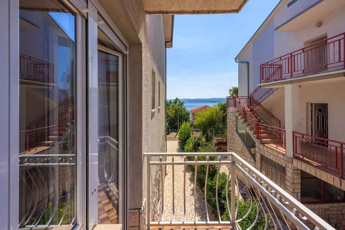 Uma varanda com vista para um pátio e uma paisagem distante.