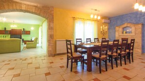 A dining area with a stone archway, a green sofa, and a fireplace. - Beautiful home in Vodnjan (Vodnjan)
