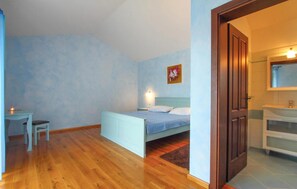A bedroom with a bed, bedside table, chair, and a painting on the wall. - Beautiful home in Vodnjan (Vodnjan)