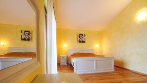 A bedroom with a bed, bedside tables, a mirror, and two wall-mounted lamps. - Beautiful home in Vodnjan (Vodnjan)