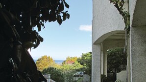 A view from a balcony with a clear sky, a garden, and a distant view of the sea. - 1 bedroom nice apartment in Bastia (Bastia)