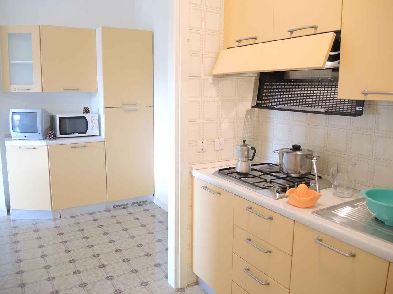 Une cuisine équipée d’une cuisinière, d’un four à micro-ondes et de placards.