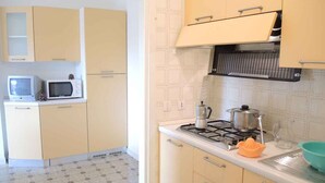 A kitchen with a stove, microwave, and cabinets.