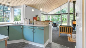 A modern kitchen with a large island, wooden ceiling, and large windows offering a view of the outdoors. - Amazing home in Ebeltoft with sauna (Ebeltoft)