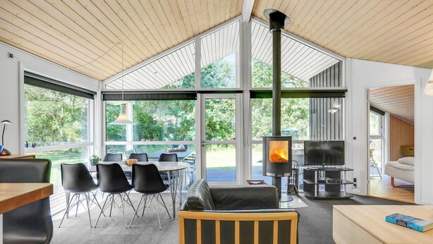 A modern interior with a large open space, a fireplace, a dining area with chairs, and a sofa. - Amazing home in Ebeltoft with sauna (Ebeltoft)