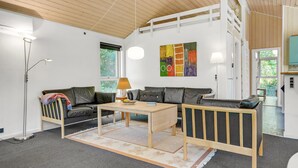A modern living room with a sofa, coffee table, and floor lamp. - Amazing home in Ebeltoft with sauna (Ebeltoft)