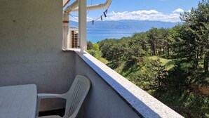 A balcony with a view of a forest and a body of water. - Holiday apartment with air conditioning (Baška)