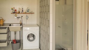 A laundry room with a washing machine, a sink, and a shower. - Stunning home in Hovmantorp with WiFi (Hovmantorp)