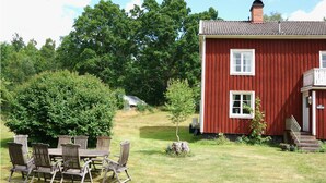 A red wooden house with two windows, a chimney, and a small porch. - Stunning home in Hovmantorp with WiFi (Hovmantorp)