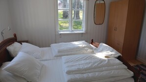 Un dormitorio con cama, ventana, armario y espejo.