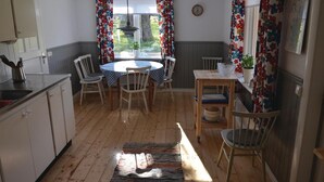Una cocina acogedora con una mesa redonda, sillas y piso de madera.