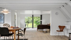 Ein geräumiges Zimmer mit Essbereich, einer Couch und einer Treppe.