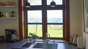 Eine Küche mit großem Fenster, einer Kaffeemaschine und einem Spülbecken.