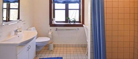 A bathroom with a sink, toilet, and bathtub.