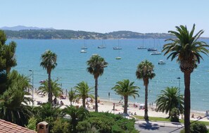 A beach with palm trees, a sandy shore, and boats in the water. - Pet friendly home in Trets (Trets)