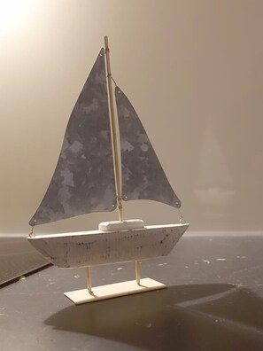 A model sailboat on a flat surface. - Ferienwohnungen Ostseeblick (Kronsgaard)