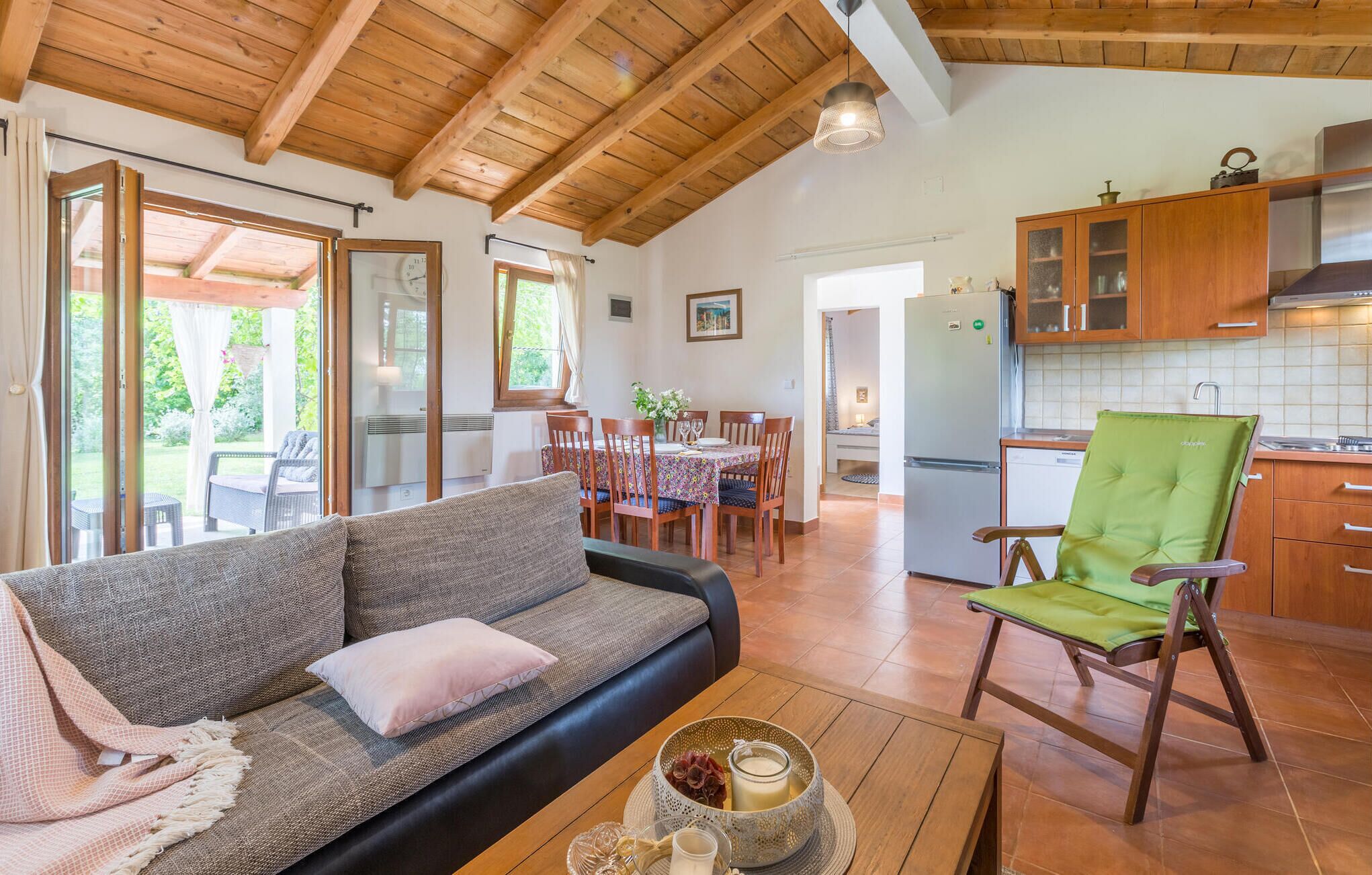 Un espacio acogedor con sofá, mesa de comedor y cocina con armarios de madera.