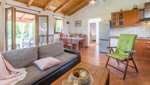Un espacio acogedor con sofá, mesa de comedor y cocina con armarios de madera.