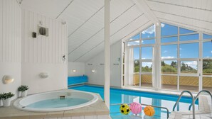 An indoor swimming pool with a view of the outdoors, a hot tub, and a deck area. - Nice home in Rudkøbing with sauna (Rudkøbing)
