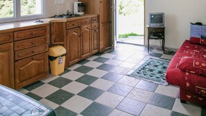 Una cocina con armarios de madera, una cafetera y un cubo de basura.