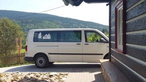 A white van parked in front of a log cabin with a stone pathway leading to the entrance. - Holiday home with stylish wooden furniture (Horní Maršov)
