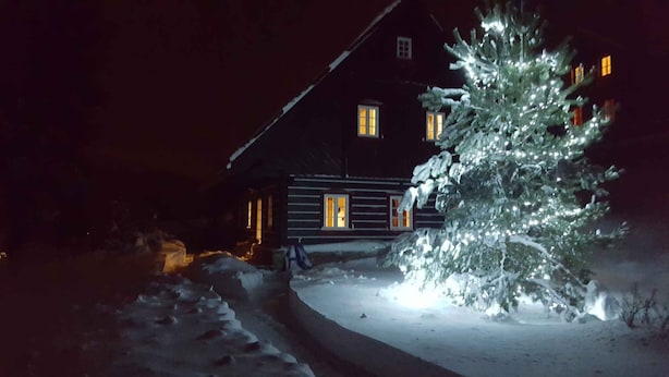 A snow-covered landscape with a house and a decorated Christmas tree. - Holiday home with stylish wooden furniture (Horní Maršov)