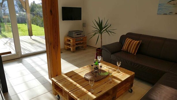 Un salon avec une table basse en bois, un canapé en cuir marron et une plante en pot.