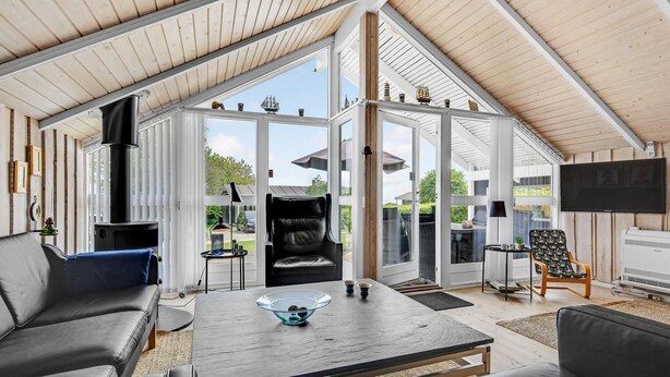 Un amplio salón con un ventanal grande, chimenea y televisor.