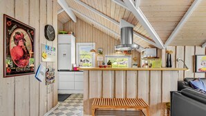 Una cocina acogedora con paredes de madera, una isla central y una banca.