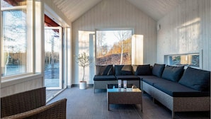 A modern living room with a large sofa, a coffee table, and a potted plant. - Stunning home in Holmsjö with kitchen (Holmsj ö)