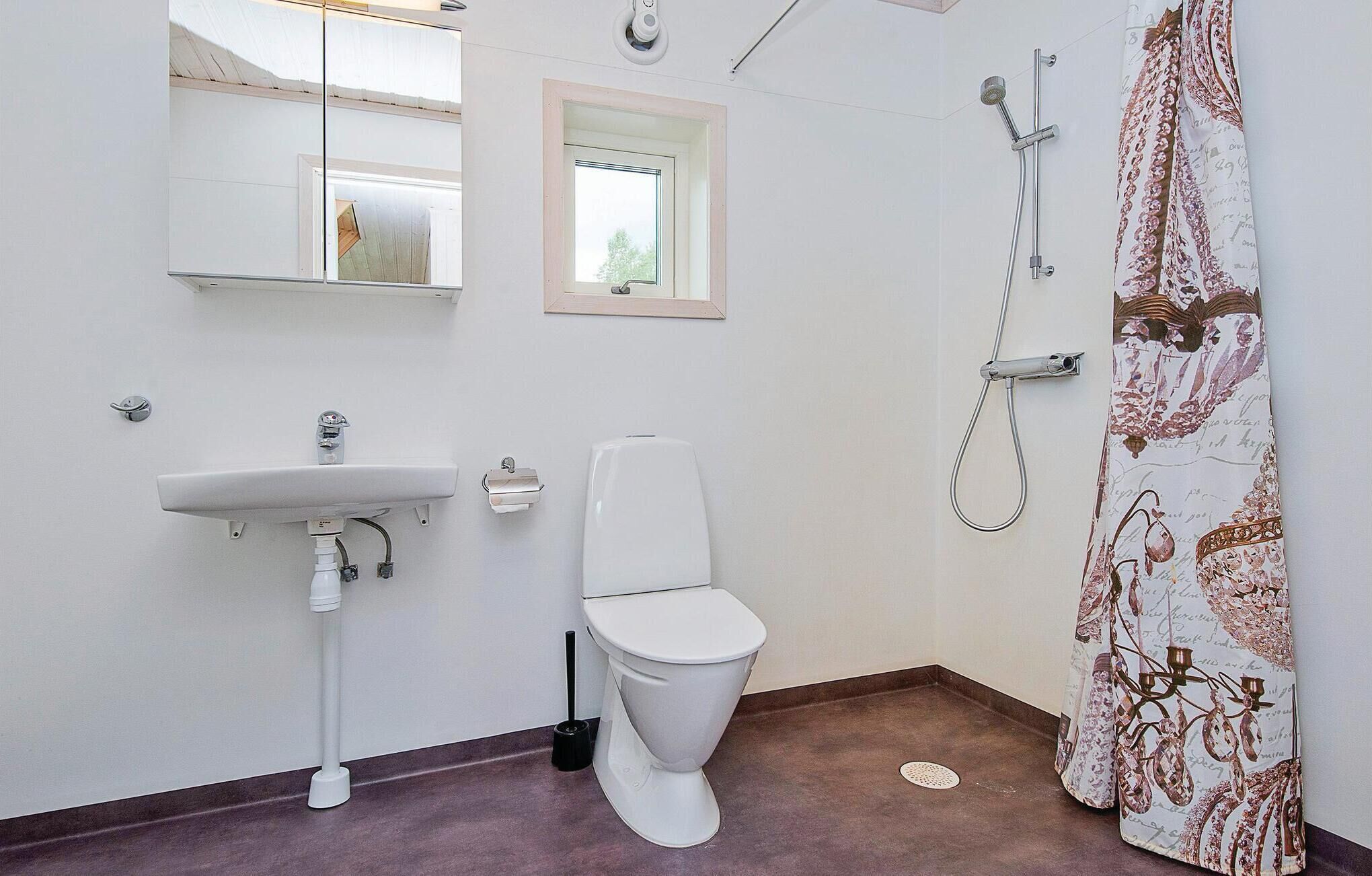 A bathroom with a white sink, toilet, and shower.