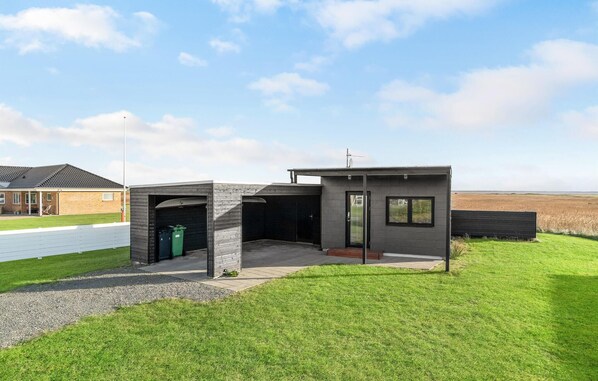 Un bâtiment moderne doté d’un garage, d’un petit bureau et d’un espace d’observation avec une fenêtre.