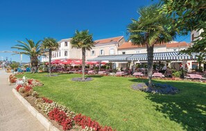 Enjoy casual dining under striped awnings surrounded by lush gardens and traditional architecture.