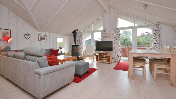 A spacious living room with a sofa, a TV, a fireplace, and a dining area with a table and chairs. - Amazing home in Fanø with WiFi (Fanø)